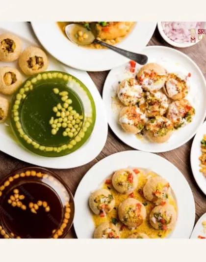 We believe in offering variety. This overhead shot showcases a part of our extensive chaat menu, featuring different types of puris and flavored water, ready to delight your guests.