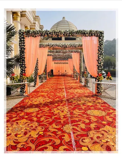 A classic wedding entrance in front of a grand building. The peach drapes and floral-topped pillars perfectly complement the traditional architecture.