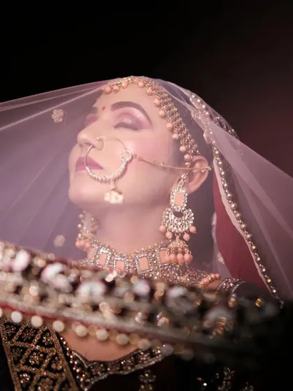 A classic bridal portrait with a modern, artistic touch. We use light and shadow to capture the bride's serene beauty and anticipation from behind her veil.