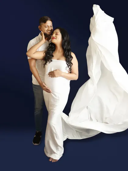 A powerful couple's portrait using a flowing white drape. The deep blue background provides a stunning contrast, making the subjects pop.