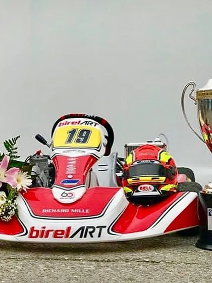 A closer look at the world championship trophy alongside the race-winning kart. Every component is engineered for victory, a philosophy we apply to all our race machines.