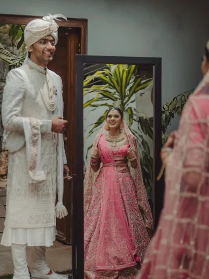 A quiet moment of reflection before the ceremony. This image of Prerna and Viraj captures the anticipation and beauty of the wedding day, with the bride's reflection adding a poetic touch.