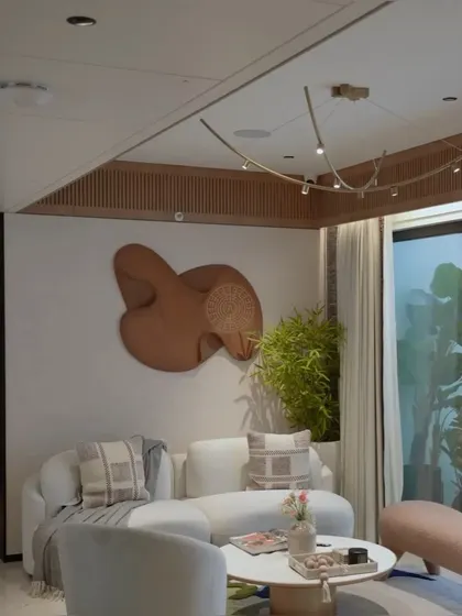A detail shot of the living room, showing the curved white sofa and a sculptural wooden art piece on the wall. Every piece of furniture was custom-made to fit the space and aesthetic perfectly.