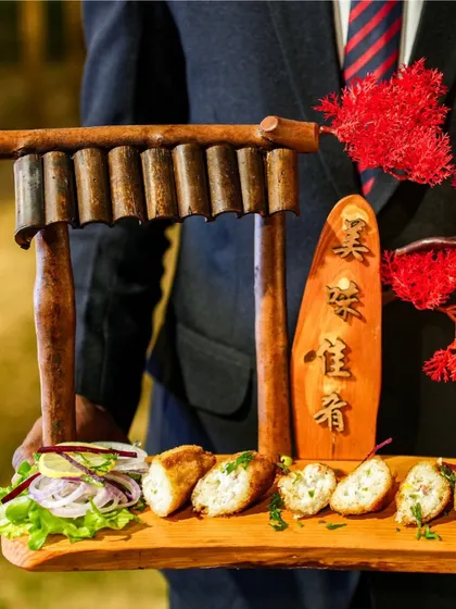 An artfully presented platter of chicken starters, served on a wooden board with a miniature Japanese Torii gate. This showcases our ability to blend culinary themes with creative presentation.