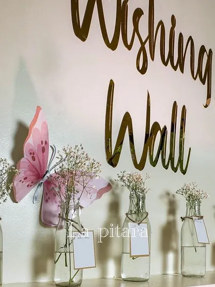 A close-up of the 'Wishing Wall', where guests can leave messages for the baby in small glass bottles.