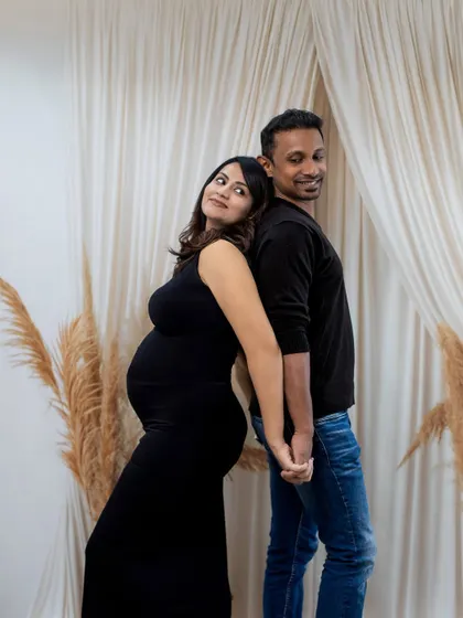 A fun and sweet back-to-back pose, showing the playful connection between the couple.