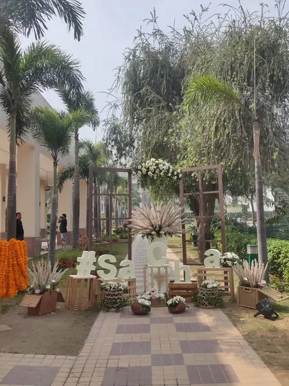 A wider view of the personalized welcome area, showing how it is positioned along the guest pathway. The setup includes a hanging marigold garland, adding a traditional touch.