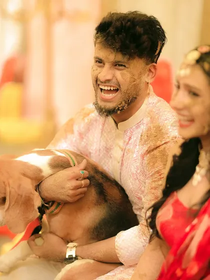 Even the furry family members get in on the Haldi fun! A joyful, candid moment with the couple and their dog.