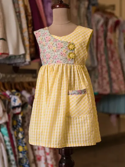Another view of the yellow gingham and floral dress, highlighting its sunny disposition and playful design.