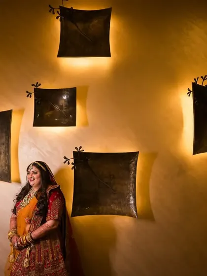 A creative portrait of the bride, Dhwani, using warm, artistic wall lighting to create a unique and memorable shot.