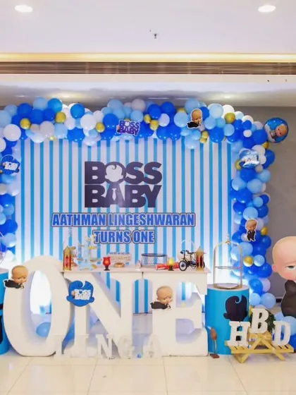 This Boss Baby setup for Linga's first birthday was all about the details. We used a blue and white striped backdrop, a full balloon arch with character balloons, and a custom "ONE" table, making sure the little boss had a memorable celebration.