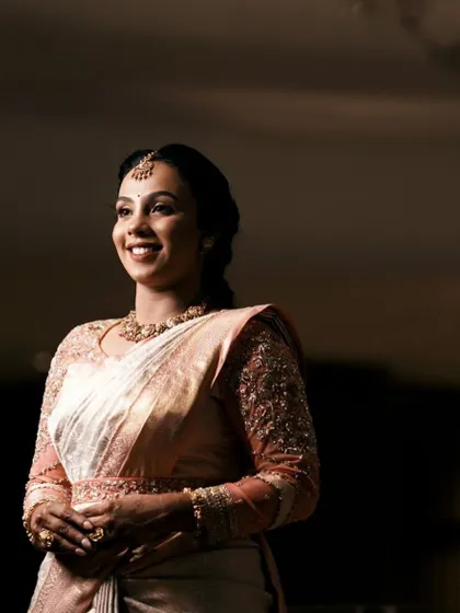 An elegant portrait of the bride, where the lighting beautifully highlights the shimmer of her saree and the detailed work on her blouse.