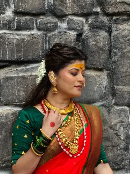 A powerful and divine look for Savaniee Ravindrra's music video "Udo Ambabaicha". This traditional look features a red and green Navratri saree, heavy gold jewelry, and bold, expressive makeup.