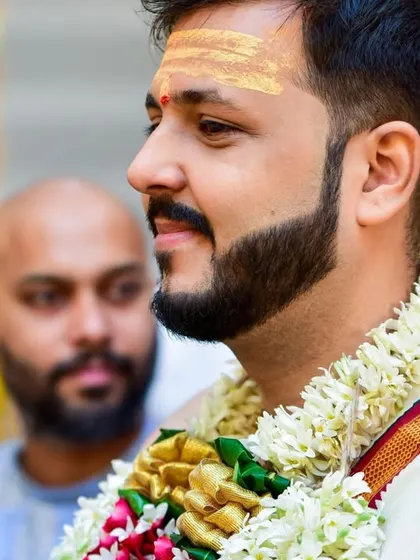 A profile shot of the groom during the wedding ceremony, highlighting the traditional tripundra on his forehead.