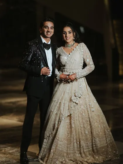 The happy couple, ready for their Sangeet night. The bride's elegant white gown-lehenga and my signature soft glam makeup create a look of modern sophistication.