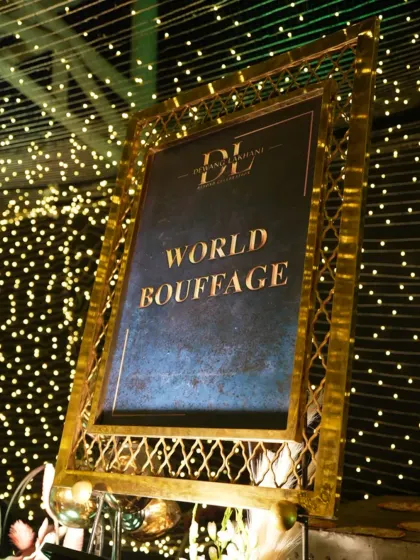 Our "World Bouffage" signage, framed in ornate gold against a backdrop of fairy lights. This signals to guests that they are about to embark on a global culinary journey.