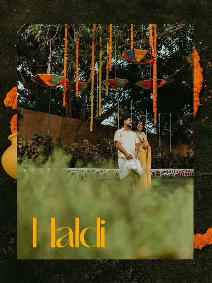 An artistic shot of the couple standing under a tree decorated for their Haldi, framed by greenery.