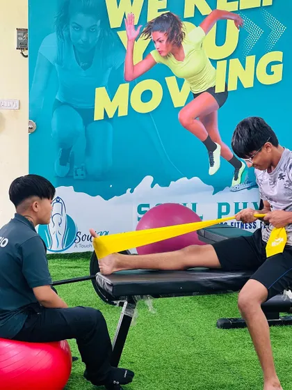"Let the beauty of what you love be what you do." A physiotherapist works with a young athlete, demonstrating our passion for helping clients achieve their goals.