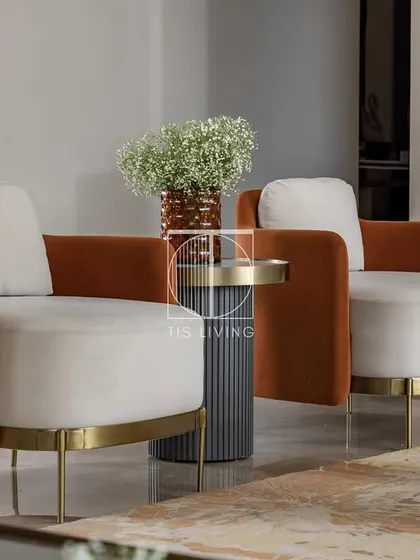 The armchairs in this drawing room feature a bold, burnt-orange fabric and a unique wrap-around design. We created these as accent pieces to introduce color and a strong silhouette to the neutral space.