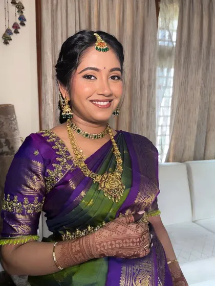 A bright and happy portrait from a Seemantha ceremony. The makeup enhances her natural glow, and the traditional attire makes for beautiful, lasting memories.