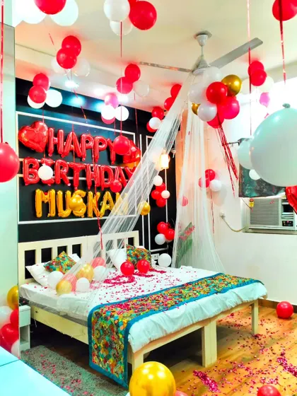 This romantic bedroom setup for "Muskan" shows a mix of red, white, and gold balloons, creating a warm and celebratory feel.