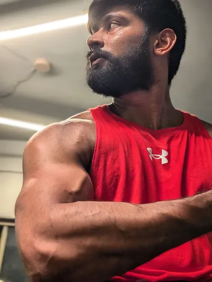 "Dedication, motivation, transformation." A powerful arm flex, showing the results of a disciplined lifestyle.