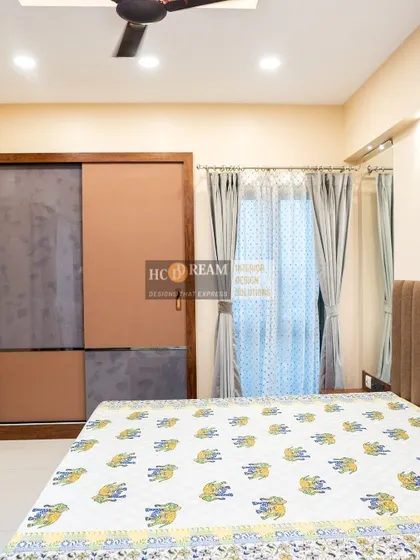 A cozy bedroom with a sliding wardrobe in a two-tone wood and grey finish. The simple design and neutral color palette make the room feel calm and uncluttered.