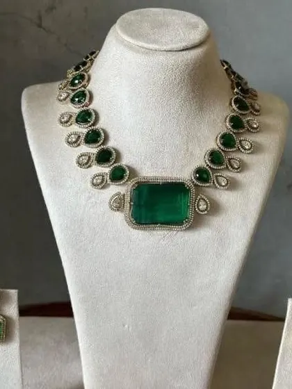 This single-layer Victorian necklace with a large rectangular green stone is a statement piece. It comes with matching earrings and is perfect for a minimalist but bold look.