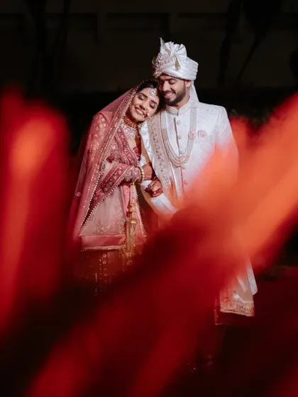 A romantic portrait of Akash and Nikita, framed by a soft red foreground, creating a dreamy and intimate feel.