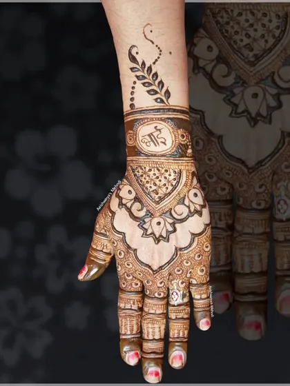 An elegant back-hand design personalized with the brother's initial for the festival of Raksha Bandhan.