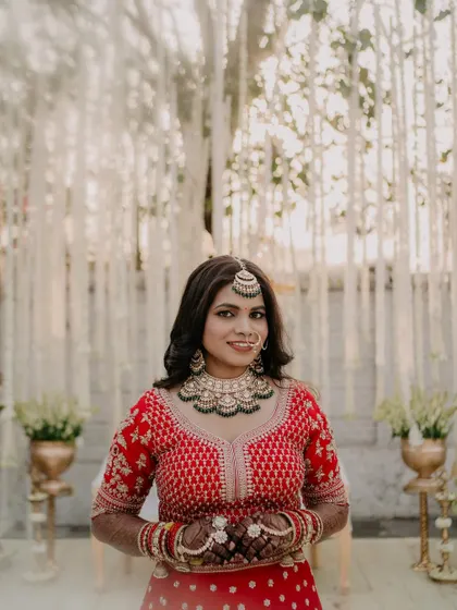 A full-frontal portrait showcasing the complete look. The makeup, hair, and outfit come together to create a stunning and cohesive bridal style.