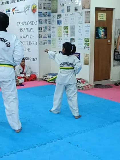 A senior student demonstrates a form for a junior student.