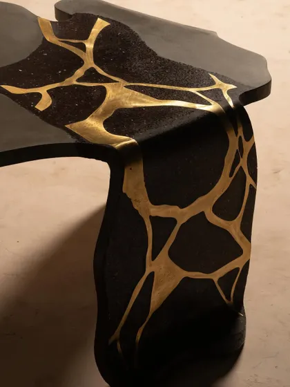 Bold black concrete meets luxurious gold brass inlay in this table from our Coral Collection. The design is inspired by the fluid, organic movement of coral, creating a piece that is both sculptural and functional.