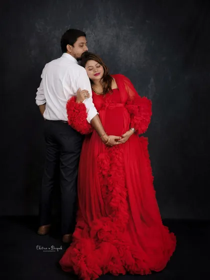 A romantic and elegant pose against a dark backdrop. The way she leans on him shows trust and affection.