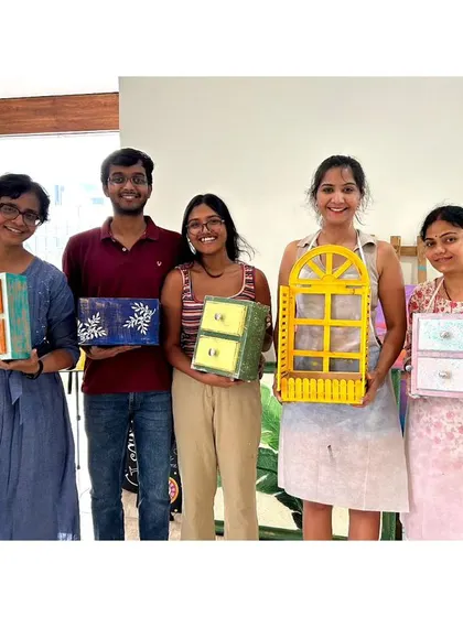 The whole group from a wood distressing workshop, showing off their beautifully upcycled drawers and decor items.