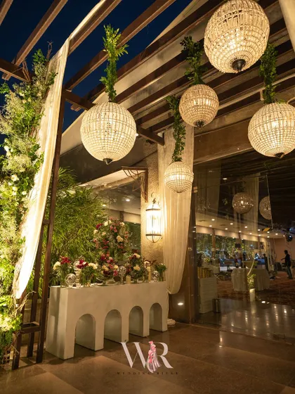 Another view of the entrance console, framed by hanging beaded chandeliers and lush greenery, creating a sophisticated and welcoming first impression.