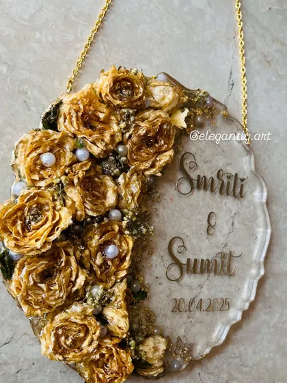 A beautiful wall hanging frame made from a preserved varmala. The golden roses and pearls create a stunning visual against the clear resin.