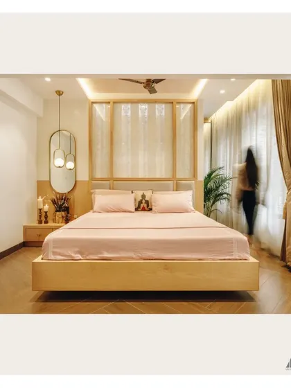 This wide shot captures the full expanse of the bedroom, including the wooden flooring and the flow of natural light from the large windows, creating a bright and airy sanctuary.