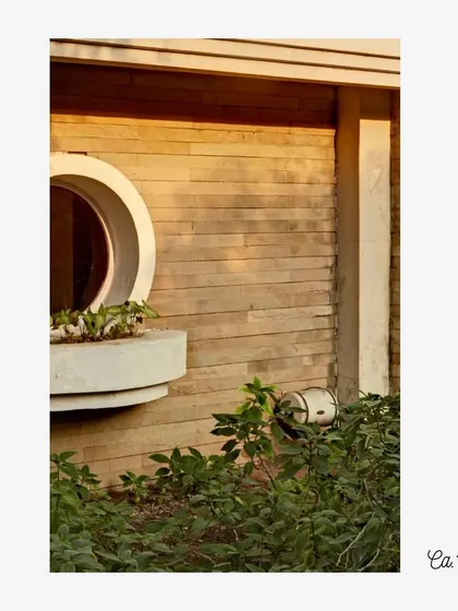 The circular window and textured stone wall at Tata Chemicals, Babrala (c. 1996). This composition shows our focus on creating visual interest through the interplay of simple geometric forms and natural material textures.