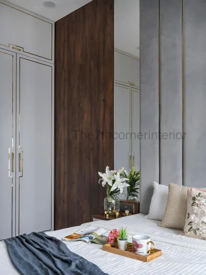 This view highlights the hidden bathroom door, seamlessly integrated into a wood-paneled wall, which sits beside the wardrobe. This technique maintains a clean, uninterrupted aesthetic.