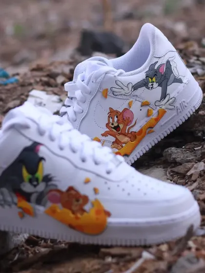 A shot of the Tom & Jerry custom sneakers on a rocky surface, giving them a rugged, playful feel.