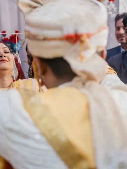 A candid moment during the mangalsutra ceremony, with guests smiling and celebrating in the background.