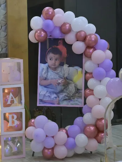 A sweet photo display for Vamika, framed by a crescent-shaped balloon arrangement and "BABY" blocks.