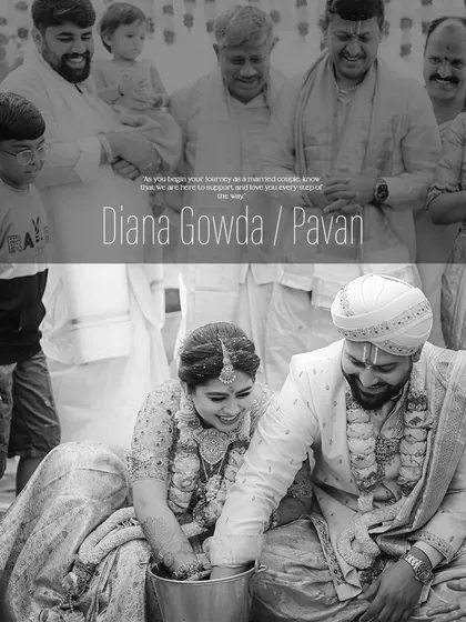 A candid black and white photo capturing a fun wedding ritual. Even in monochrome, the texture and detail of the custom bridal blouse and groom's sherwani are apparent.