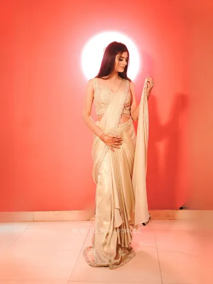 A full-length view of the golden drape saree, showing its beautiful sheen and modern silhouette.