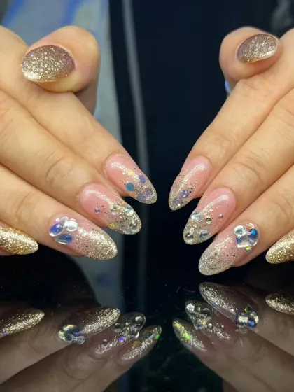 A full view of the glamorous gold glitter and rhinestone nail set.