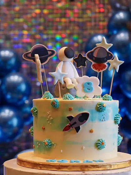 A space-themed cake that's out of this world. The details, from the astronaut topper to the planets and stars, are perfectly coordinated with the overall party decor.