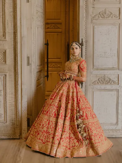A full-length portrait of the bride, looking every bit a queen against a backdrop of ornate doors.