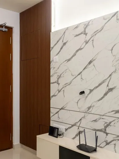 The TV unit in this Hyderabad home features a stunning marble-finish panel that serves as a focal point, complemented by simple, clean-lined cabinetry.