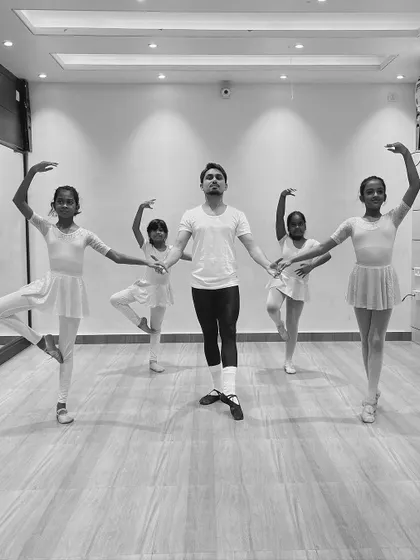 A group of young ballerinas in a synchronized pose with me during a class. These photos show the discipline and coordination we build in our ballet program.